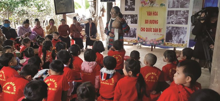 Nhà nghiên cứu văn hóa dân gian Đỗ Thị Tấc đang dạy cho trẻ con về cây đàn tính tẩu.